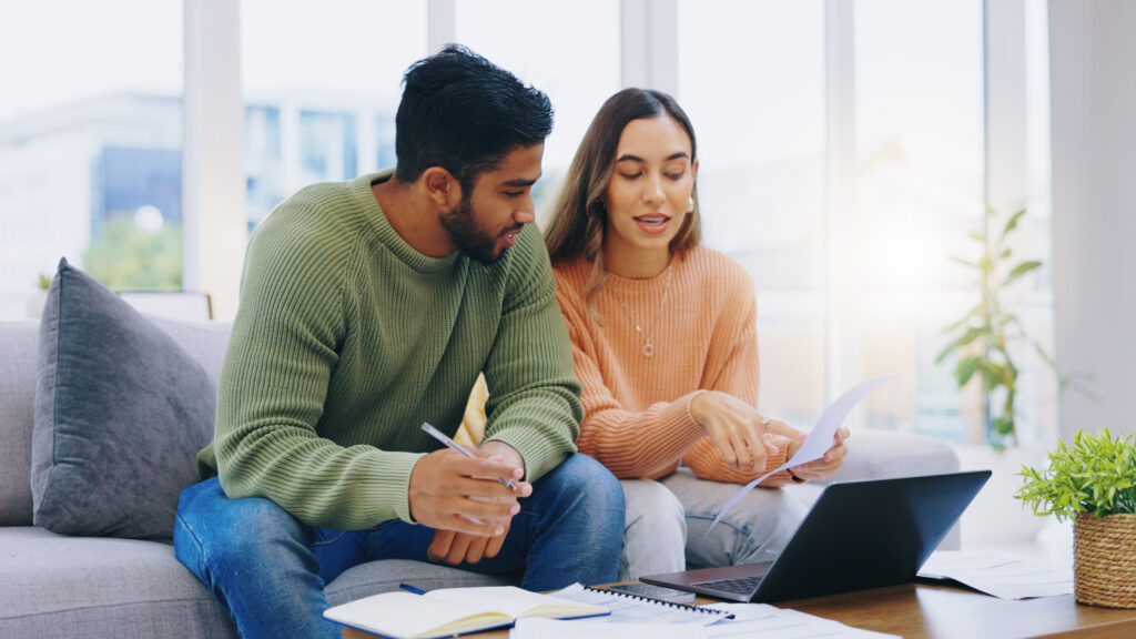 Laptop, documents and couple on sofa for taxes, online banking and budget payment. Living room, home and man and woman help with paperwork, bills and computer for insurance, savings and finances.